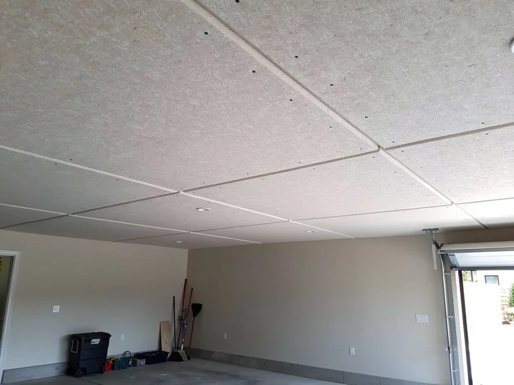 Panneaux isolants fixés sous le plancher d'un garage attenant